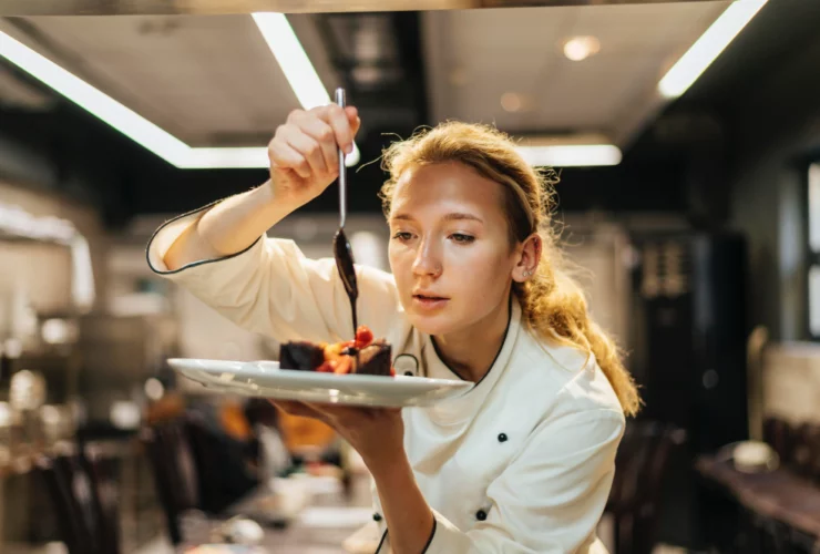 Une étudiante en cuisine dresse une assiette